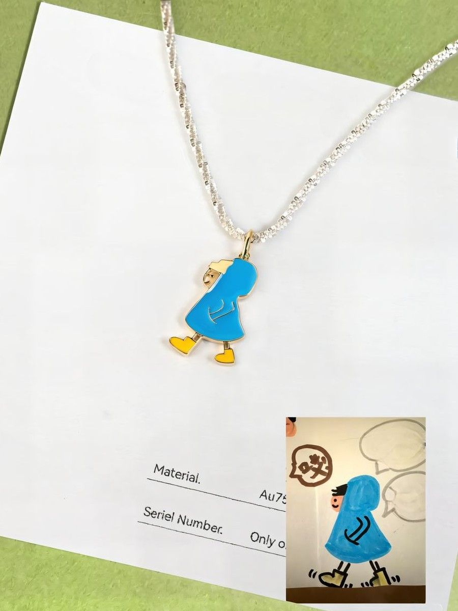 The same blue enamel pendant next to the child's drawing it was made from