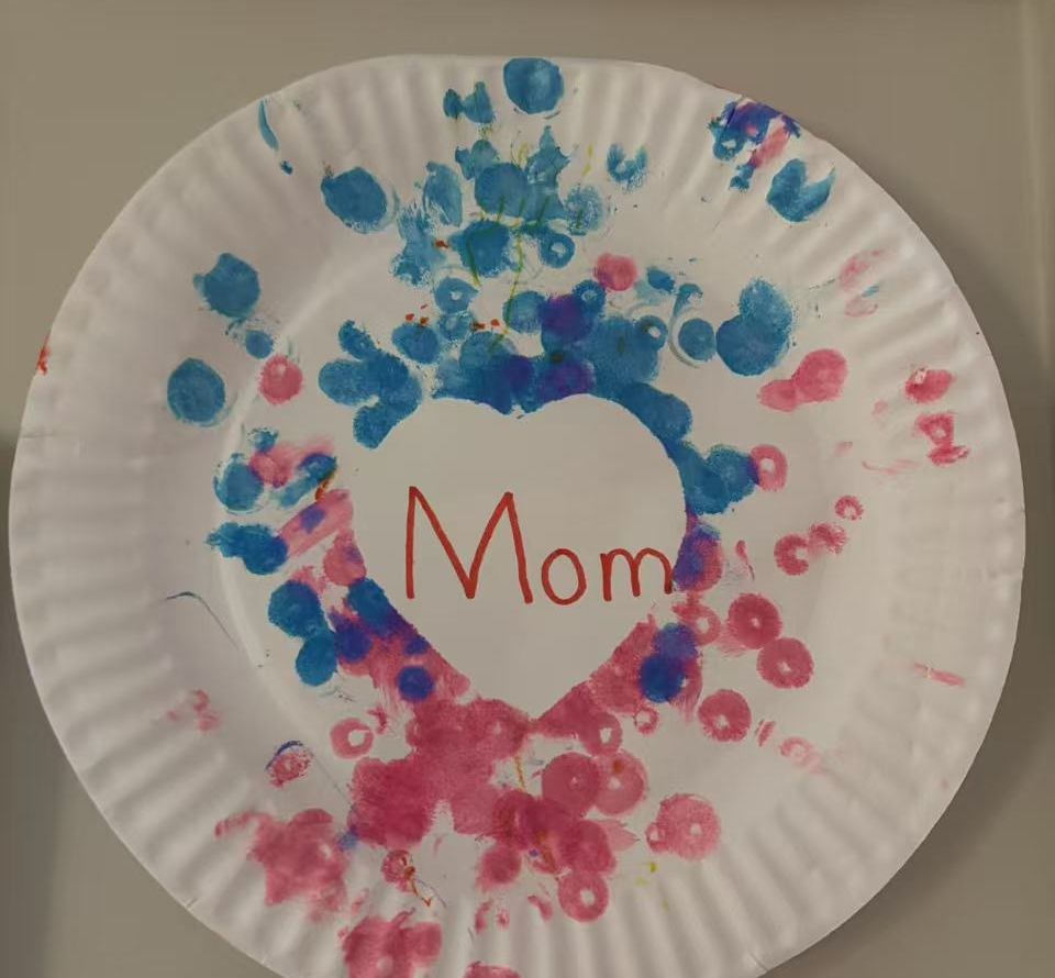 Paper plate painted with pink and blue dots around a heart that says Mom