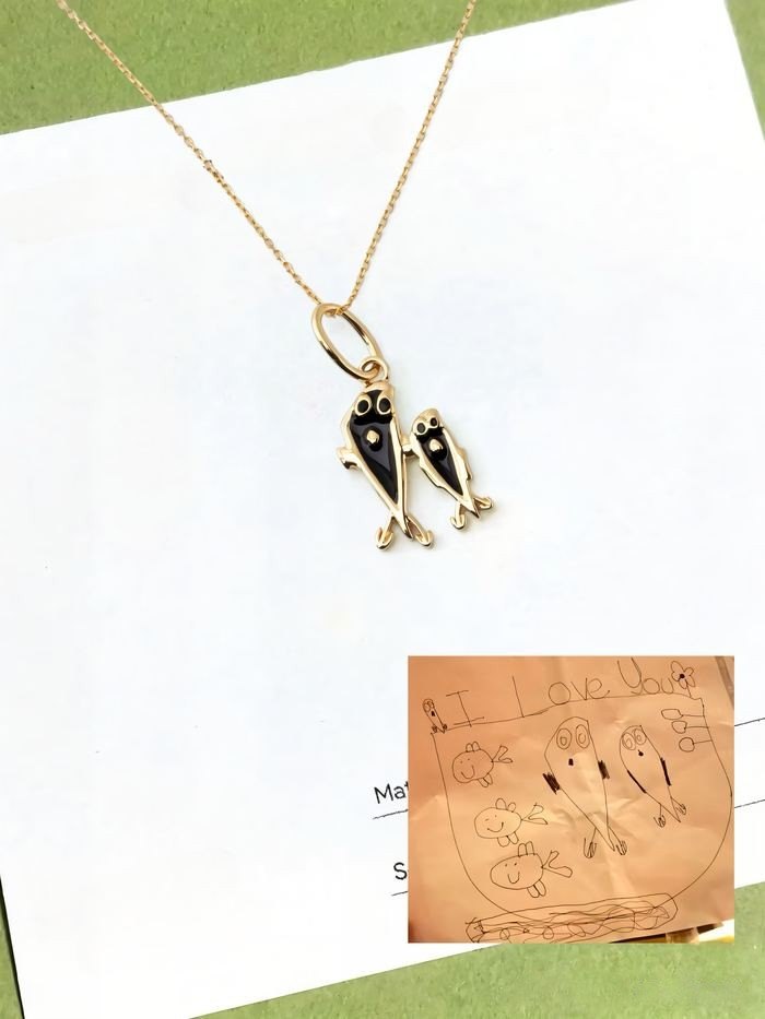 Two fish from a drawing as a gold and black enamel pendant